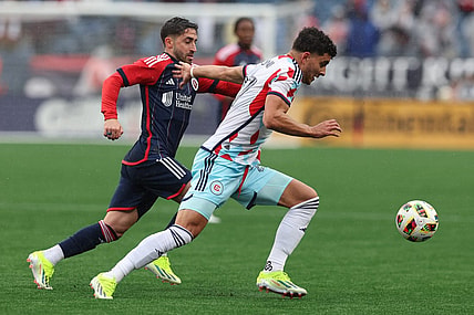 Mar 23, 2024; Foxborough, Massachusetts, USA; Chicago Fire FC defender Allan Arigoni (27) plays the ball defended by New England Revolution midfielder Nacho Gil (21) in the first half at Gillette Stadium. Mandatory Credit: Paul Rutherford-USA TODAY Sports