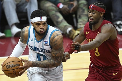 Mar 25, 2024; Cleveland, Ohio, USA; Charlotte Hornets forward Miles Bridges (0) looks to pass beside Cleveland Cavaliers guard Caris LeVert (3) in the fourth quarter at Rocket Mortgage FieldHouse. Mandatory Credit: David Richard-USA TODAY Sports