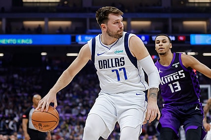 Mar 26, 2024; Sacramento, California, USA; Dallas Mavericks guard Luka Doncic (77) passes the ball against Sacramento Kings forward Keegan Murray (13) during the first quarter at Golden 1 Center. Mandatory Credit: Sergio Estrada-USA TODAY Sports