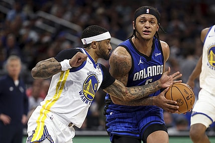 Mar 27, 2024; Orlando, Florida, USA;  Orlando Magic forward Paolo Banchero (5) drives the ball past Golden State Warriors guard Gary Payton II (0) in the second quarter at the Kia Center. Mandatory Credit: Nathan Ray Seebeck-USA TODAY Sports