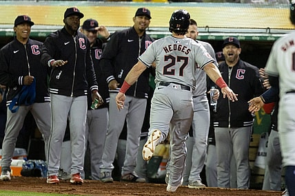 Mar 28, 2024; Oakland, California, USA; Cleveland Guardians catcher Austin Hedges (27) is greeted by his teammates after scoring on a two-RBI double by Brayan Rocchio against the Oakland Athletics during the fourth inning at Oakland-Alameda County Coliseum. Mandatory Credit: D. Ross Cameron-USA TODAY Sports