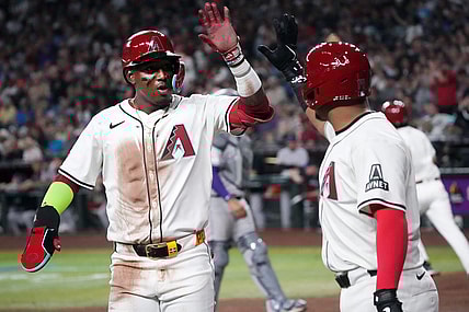 Arizona Diamondbacks Geraldo Perdomo (2) high-fives teammate Gabriel Moreno (14) after scoring a run against the Colorado Rockies on Opening Day at Chase Field.