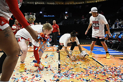 Mar 31, 2024; Portland, OR, USA; NC State Wolfpack guard Aziaha James (10) slides in confetti with teammates, forward Maddie Cox (11) and guard Zoe Brooks (35) in celebration after a game against the Texas Longhorns in the finals of the Portland Regional of the NCAA Tournament at the Moda Center center. Mandatory Credit: Troy Wayrynen-USA TODAY Sports
