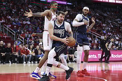 Mar 31, 2024; Houston, Texas, USA; Dallas Mavericks guard Luka Doncic (77) grabs a rebound away from Houston Rockets forward Jabari Smith Jr. (10) during the first quarter at Toyota Center. Mandatory Credit: Troy Taormina-USA TODAY Sports