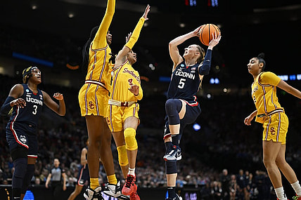 Apr 1, 2024; Portland, OR, USA; UConn Huskies guard Paige Bueckers (5) drives to the basket during the first half against USC Trojans guard Kayla Williams (4) and center Clarice Akunwafo (34)in the finals of the Portland Regional of the NCAA Tournament at the Moda Center. Mandatory Credit: Troy Wayrynen-USA TODAY Sports
