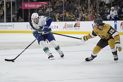 Vancouver Canucks right wing Brock Boeser (6) skates up the ice against Vegas Golden Knights defenseman Noah Hanifin (15) during the third period of an NHL hockey game Tuesday, April 2, 2024, in Las Vegas. (AP Photo/John Locher)