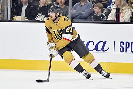 Vegas Golden Knights defenseman Shea Theodore (27) handles the puck against the Calgary Flames during the first period of an NHL hockey game Sunday, Dec. 29, 2024, in Las Vegas. (AP Photo/David Becker)