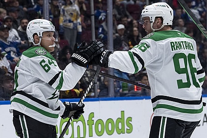 Dallas Stars' Mikael Granlund (64) and Mikko Rantanen (96) celebrate Granlund's goal against the Vancouver Canucks during the second period of an NHL hockey game in Vancouver, British Columbia, Sunday, March 9, 2025. (Ethan Cairns/The Canadian Press via AP)