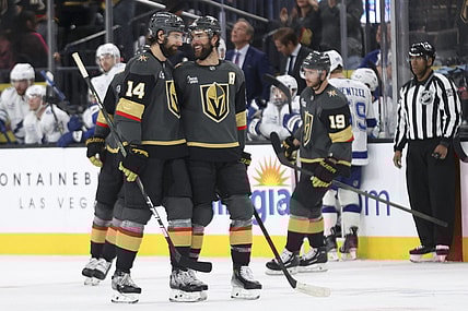 Vegas Golden Knights defensemen Nicolas Hague (14) and Alex Pietrangelo (7) celebrate after Hague's goal during the third period of an NHL hockey game against the Tampa Bay Lightning, Sunday, March 23, 2025, in Las Vegas. (AP Photo/Ian Maule)