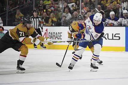 Edmonton Oilers right wing Vasily Podkolzin (92) knocks the puck up the ice against Vegas Golden Knights center William Karlsson (71) during the first period of an NHL hockey game Tuesday, April 1, 2025, in Las Vegas. (AP Photo/John Locher)