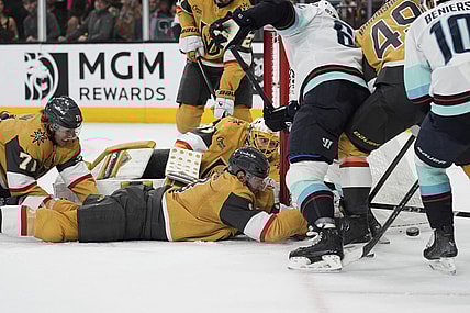 Vegas Golden Knights defenseman Brayden McNabb (3) lies on the ice while battling for th puck against the Seattle Kraken during the third period of an NHL hockey game Thursday, April 10, 2025, in Las Vegas. (AP Photo/John Locher)