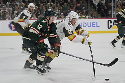 Minnesota Wild left wing Matt Boldy (12) and Vegas Golden Knights center Jack Eichel (9) battle for the puck during the first period of Game 3 of a first-round NHL hockey playoff series Thursday, April 24, 2025, in St. Paul, Minn. (AP Photo/Abbie Parr)