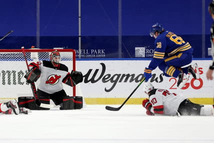 Jan 30, 2021; Buffalo, New York, USA;  New Jersey Devils goaltender Scott Wedgewood (41) watches as defenseman Dmitry Kulikov (70) blocks a shot by Buffalo Sabres right wing Victor Olofsson (68) during the third period at KeyBank Center. Mandatory Credit: Timothy T. Ludwig-USA TODAY Sports