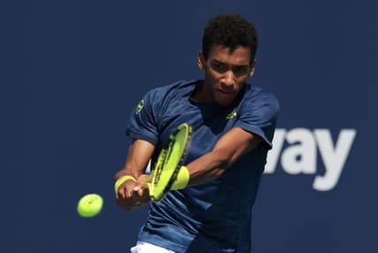 Mar 28, 2021; Miami, Florida, USA; Felix Auger-Aliassime of Canada hits a backhand against John Isner of the United States (not pictured) in the third round in the Miami Open at Hard Rock Stadium. Mandatory Credit: Geoff Burke-USA TODAY Sports