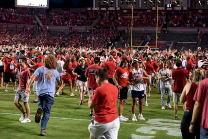 Sep 25, 2021; Raleigh, North Carolina, USA; North Carolina State Wolfpack fans storm the field after a win against the Clemson Tigers at Carter-Finley Stadium. Mandatory Credit: Rob Kinnan-USA TODAY Sports