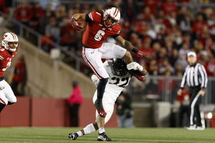 Oct 16, 2021; Madison, Wisconsin, USA;  Wisconsin Badgers running back Chez Mellusi (6) leaps over Army Black Knights defensive back Cedrick Cunningham Jr. (22) during the third quarter at Camp Randall Stadium. Mandatory Credit: Jeff Hanisch-USA TODAY Sports
