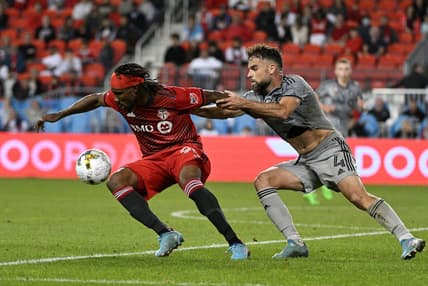 Sep 4, 2022; Toronto, Ontario, CAN;  Toronto FC forward Ifunanyachi Achara (99) tries to get away from CF Montreal defender Rudy Camacho (4) in the second half at BMO Field. Mandatory Credit: Dan Hamilton-USA TODAY Sports