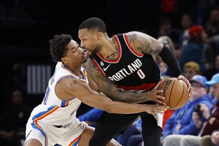 Dec 19, 2022; Oklahoma City, Oklahoma, USA; Portland Trail Blazers guard Damian Lillard (0) is defended by Oklahoma City Thunder guard Aaron Wiggins (21) on a drive during the second half at Paycom Center. Oklahoma City won 123-121. Mandatory Credit: Alonzo Adams-USA TODAY Sports