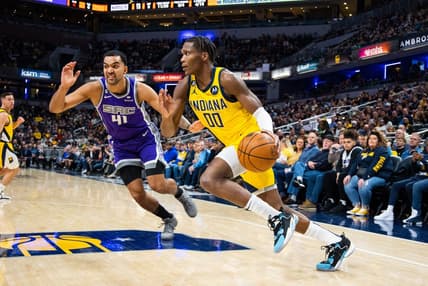 Feb 3, 2023; Indianapolis, Indiana, USA; Indiana Pacers guard Bennedict Mathurin (00) dribbles the ball while Sacramento Kings forward Trey Lyles (41) defends in the second quarter at Gainbridge Fieldhouse. Mandatory Credit: Trevor Ruszkowski-USA TODAY Sports
