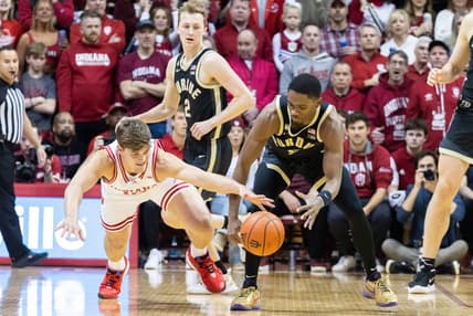 Feb 4, 2023; Bloomington, Indiana, USA; Indiana Hoosiers forward Miller Kopp (12) and Purdue Boilermakers guard Brandon Newman (5) dive for a loose ball in the first half at Simon Skjodt Assembly Hall. Mandatory Credit: Trevor Ruszkowski-USA TODAY Sports