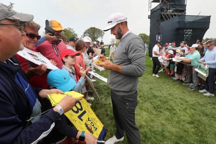 LIV Golf star Dustin Johnson stops to sign autographs after a practice round at the PGA Championship on Tuesday, May 16, 2023.