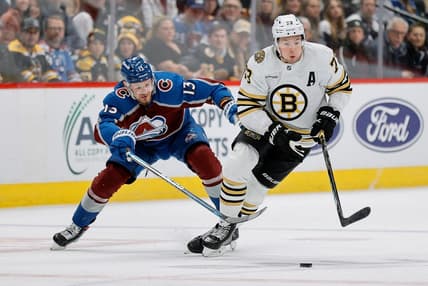 Jan 8, 2024; Denver, Colorado, USA; Boston Bruins defenseman Charlie McAvoy (73) controls the puck ahead of Colorado Avalanche right wing Valeri Nichushkin (13) in the third period at Ball Arena. Mandatory Credit: Isaiah J. Downing-USA TODAY Sports
