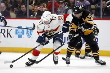 Jan 26, 2024; Pittsburgh, Pennsylvania, USA; Florida Panthers center Evan Rodrigues (17) moves the puck against pressure from Pittsburgh Penguins defenseman Kris Letang (58) during the second period at PPG Paints Arena. Mandatory Credit: Charles LeClaire-USA TODAY Sports