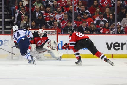 Mar 21, 2024; Newark, New Jersey, USA; New Jersey Devils goaltender Jake Allen (34) makes a save on Winnipeg Jets defenseman Josh Morrissey (44) during the second period at Prudential Center. Mandatory Credit: Ed Mulholland-USA TODAY Sports