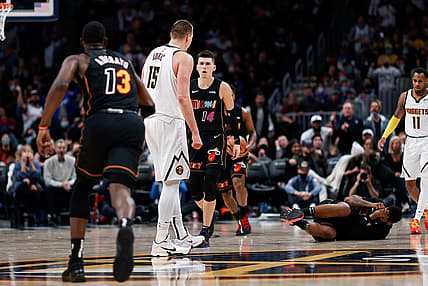 Nov 8, 2021; Denver, Colorado, USA; Miami Heat forward Markieff Morris (8) lies on the ground after a play with Denver Nuggets center Nikola Jokic (15) as guard Tyler Herro (14) and center Bam Adebayo (13) react in the fourth quarter at Ball Arena. Mandatory Credit: Isaiah J. Downing-USA TODAY Sports