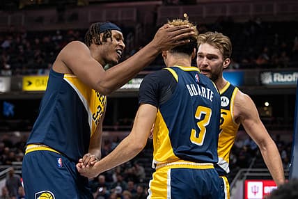 Dec 16, 2021; Indianapolis, Indiana, USA; Indiana Pacers guard Chris Duarte (3) is helped up by center Myles Turner (33) and forward Domantas Sabonis (11) in the second half against the Detroit Pistons at Gainbridge Fieldhouse. Mandatory Credit: Trevor Ruszkowski-USA TODAY Sports