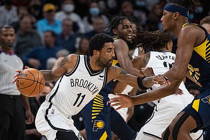 Jan 5, 2022; Indianapolis, Indiana, USA; Brooklyn Nets guard Kyrie Irving (11) dribbles the ball while Indiana Pacers center Myles Turner (33) defends in the first quarter at Gainbridge Fieldhouse. Mandatory Credit: Trevor Ruszkowski-USA TODAY Sports