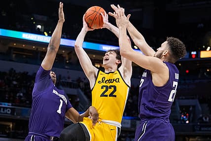 Mar 10, 2022; Indianapolis, IN, USA; Iowa Hawkeyes forward Patrick McCaffery (22) shoots the ball while Northwestern Wildcats guard Chase Audige (1) and  forward Pete Nance (22) defend in the first half at Gainbridge Fieldhouse. Mandatory Credit: Trevor Ruszkowski-USA TODAY Sports