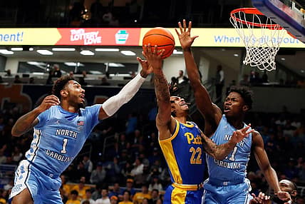Dec 30, 2022; Pittsburgh, Pennsylvania, USA;  Pittsburgh Panthers guard Nike Sibande (22) goes to the basket as North Carolina Tar Heels forward Leaky Black (1) and guard D'Marco Dunn (11) defend during the first half at the Petersen Events Center. Mandatory Credit: Charles LeClaire-USA TODAY Sports