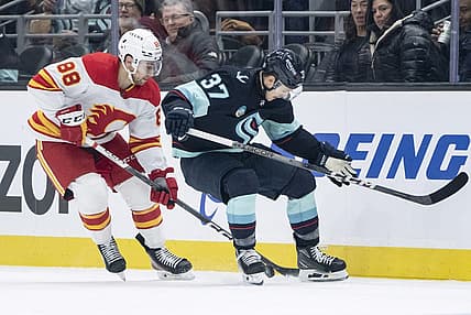 Nov 20, 2023; Seattle, Washington, USA; Seattle Kraken forward Yanni Gourde (37) and Calgary Flames forward Andrew Mangiapane (88) battle for the puck during the first period at Climate Pledge Arena. Mandatory Credit: Stephen Brashear-USA TODAY Sports