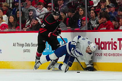 Nov 24, 2023; Raleigh, North Carolina, USA; Carolina Hurricanes defenseman Brett Pesce (22) checks Tampa Bay Lightning left wing Brandon Hagel (38) during the first period at PNC Arena. Mandatory Credit: James Guillory-USA TODAY Sports