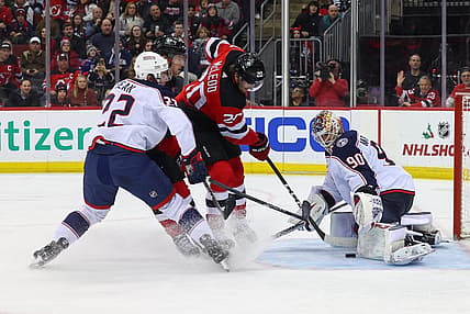 Dec 27, 2023; Newark, New Jersey, USA; Columbus Blue Jackets goaltender Elvis Merzlikins (90) makes a save on New Jersey Devils center Michael McLeod (20) during the second period at Prudential Center. Mandatory Credit: Ed Mulholland-USA TODAY Sports