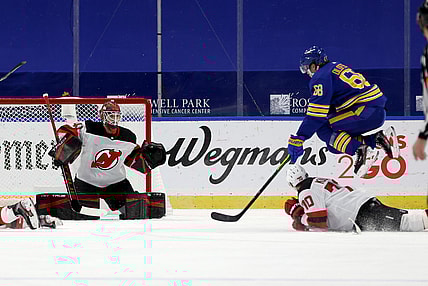 Jan 30, 2021; Buffalo, New York, USA;  New Jersey Devils goaltender Scott Wedgewood (41) watches as defenseman Dmitry Kulikov (70) blocks a shot by Buffalo Sabres right wing Victor Olofsson (68) during the third period at KeyBank Center. Mandatory Credit: Timothy T. Ludwig-USA TODAY Sports