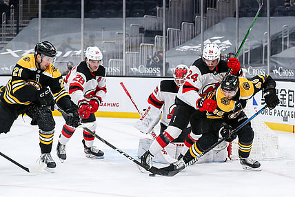 Mar 30, 2021; Boston, Massachusetts, USA; Boston Bruins left wing Nick Ritchie (21) and center David Krejci (46) and New Jersey Devils defenseman Ty Smith (24) battle for the puck during the first period at TD Garden. Mandatory Credit: Paul Rutherford-USA TODAY Sports