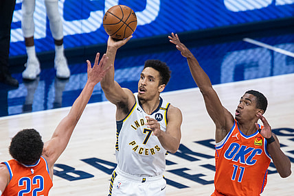 Apr 21, 2021; Indianapolis, Indiana, USA; Indiana Pacers guard Malcolm Brogdon (7) shoots the ball while Oklahoma City Thunder center Isaiah Roby (22) and guard Theo Maledon (11) defend in the second quarter at Bankers Life Fieldhouse. Mandatory Credit: Trevor Ruszkowski-USA TODAY Sports