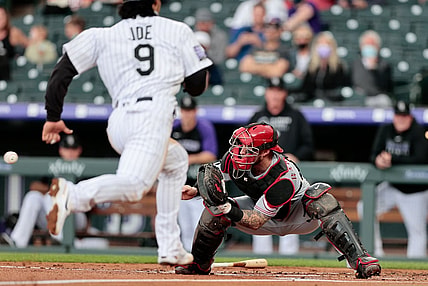 May 13, 2021; Denver, Colorado, USA; Cincinnati Reds catcher Tucker Barnhart (16) fields a throw as Colorado Rockies first baseman Connor Joe (9) runs towards home plate during the first inning at Coors Field. Mandatory Credit: Isaiah J. Downing-USA TODAY Sports