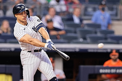 Aug 3, 2021; Bronx, New York, USA; New York Yankees designated hitter Giancarlo Stanton (27) hits an RBI single during the third inning against the Baltimore Orioles at Yankee Stadium. Mandatory Credit: Vincent Carchietta-USA TODAY Sports