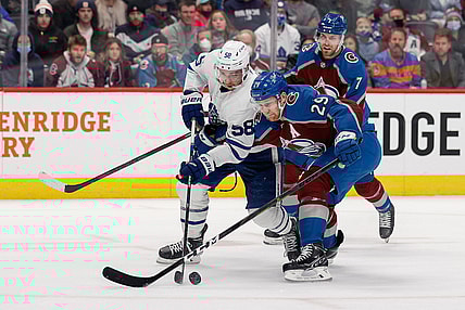 Jan 8, 2022; Denver, Colorado, USA; Toronto Maple Leafs left wing Michael Bunting (58) and Colorado Avalanche center Nathan MacKinnon (29) battle for the puck in the first period at Ball Arena. Mandatory Credit: Isaiah J. Downing-USA TODAY Sports