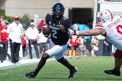 Sep 9, 2023; Boulder, Colorado, USA; Colorado Buffaloes quarterback Shedeur Sanders (2) scrambles past Nebraska Cornhuskers defensive lineman Nash Hutmacher (0) in the fourth quarter at Folsom Field. Mandatory Credit: Ron Chenoy-USA TODAY Sports