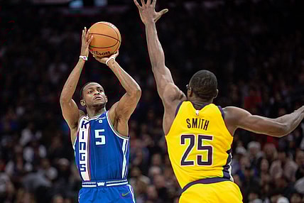 Jan 18, 2024; Sacramento, California, USA; Sacramento Kings guard De'Aaron Fox (5) takes a three point shot against Indiana Pacers forward Jalen Smith (25) during the second quarter at Golden 1 Center. Mandatory Credit: Ed Szczepanski-USA TODAY Sports