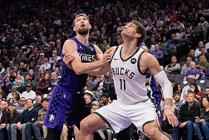 Mar 12, 2024; Sacramento, California, USA; Sacramento Kings forward Domantas Sabonis (10) and Milwaukee Bucks center Brook Lopez (11) fight for position under the basket during the second quarter at Golden 1 Center. Mandatory Credit: Ed Szczepanski-USA TODAY Sports
