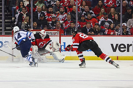 Mar 21, 2024; Newark, New Jersey, USA; New Jersey Devils goaltender Jake Allen (34) makes a save on Winnipeg Jets defenseman Josh Morrissey (44) during the second period at Prudential Center. Mandatory Credit: Ed Mulholland-USA TODAY Sports