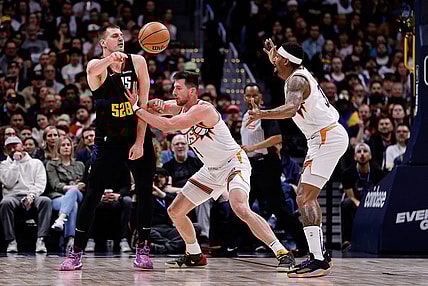 Mar 27, 2024; Denver, Colorado, USA; Denver Nuggets center Nikola Jokic (15) passes the ball against Phoenix Suns forward Drew Eubanks (14) and guard Bradley Beal (3) in the third quarter at Ball Arena. Mandatory Credit: Isaiah J. Downing-USA TODAY Sports