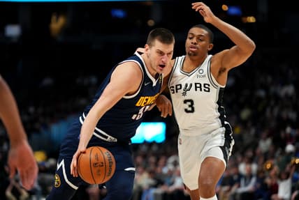 Apr 5, 2022; Denver, Colorado, USA; Denver Nuggets center Nikola Jokic (15) drives past San Antonio Spurs forward Keldon Johnson (3) in the first quarter at Ball Arena. Mandatory Credit: Ron Chenoy-USA TODAY Sports