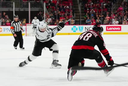 Jan 15, 2024; Raleigh, North Carolina, USA; Los Angeles Kings defenseman Drew Doughty (8) takes a shot past Carolina Hurricanes left wing Jordan Martinook (48) during the second period at PNC Arena. Mandatory Credit: James Guillory-USA TODAY Sports