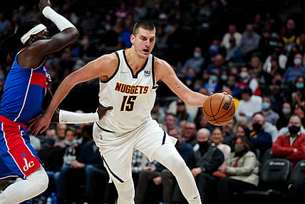 Dec 13, 2021; Denver, Colorado, USA; Denver Nuggets center Nikola Jokic (15) dribbles past Washington Wizards center Montrezl Harrell (6) in the second quarter at Ball Arena. Mandatory Credit: Ron Chenoy-USA TODAY Sports
